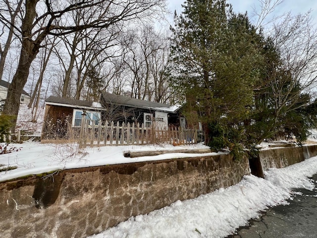 snow covered back of property with fence