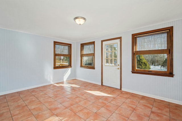 spare room with light tile patterned floors and baseboards