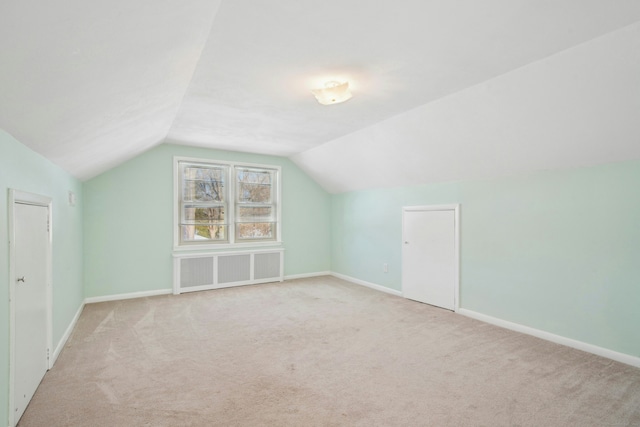 additional living space with carpet floors, vaulted ceiling, and baseboards