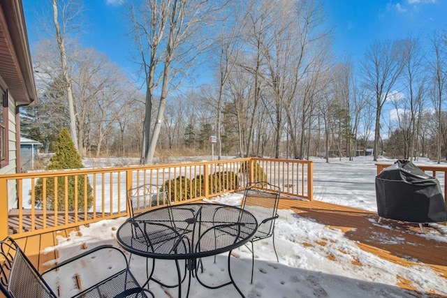 snow covered deck featuring outdoor dining space