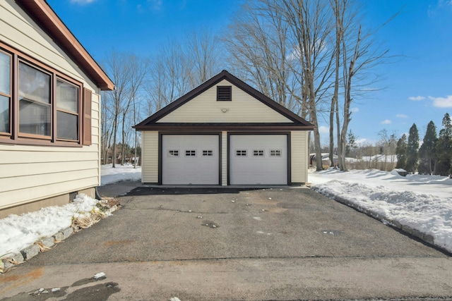 snow covered garage with a detached garage