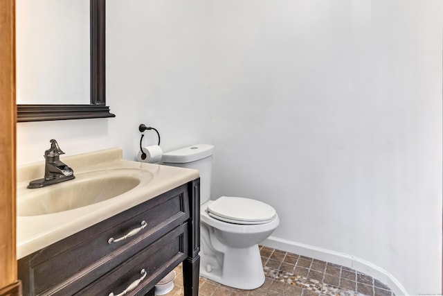 bathroom with baseboards, vanity, and toilet