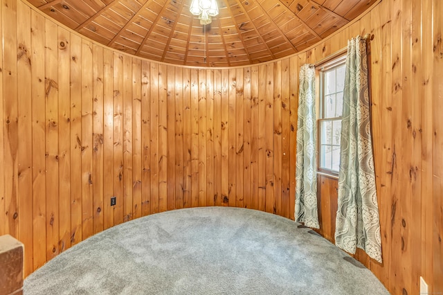 unfurnished room featuring wood ceiling and wood walls