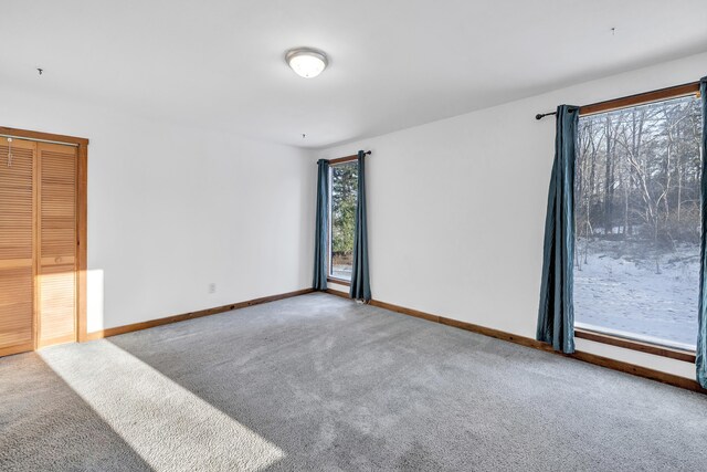 empty room featuring carpet floors and baseboards