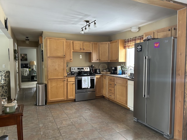 kitchen with light brown cabinets, appliances with stainless steel finishes, and a sink