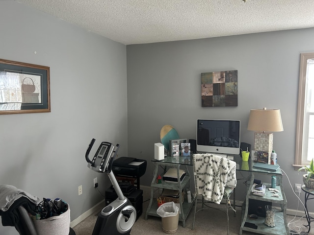 office featuring a wealth of natural light, a textured ceiling, and baseboards