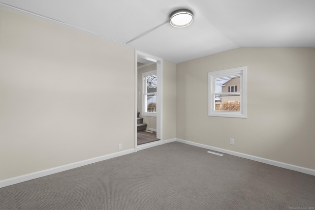 unfurnished bedroom featuring lofted ceiling, carpet, visible vents, and baseboards