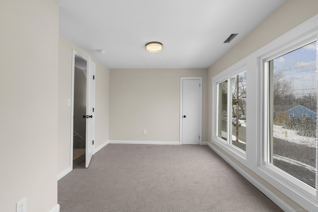 carpeted empty room featuring baseboards