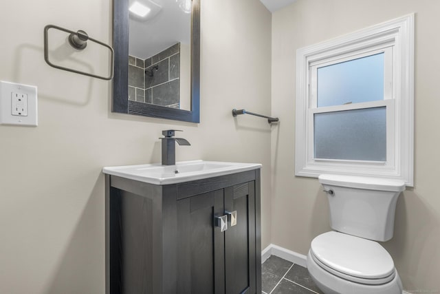 bathroom featuring toilet, tile patterned flooring, vanity, and baseboards