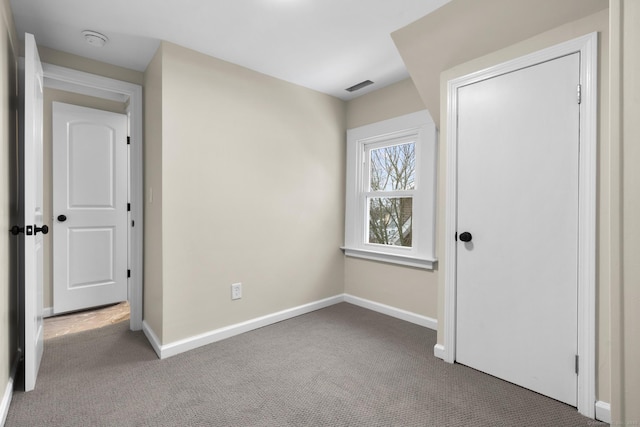 unfurnished bedroom with carpet, visible vents, and baseboards