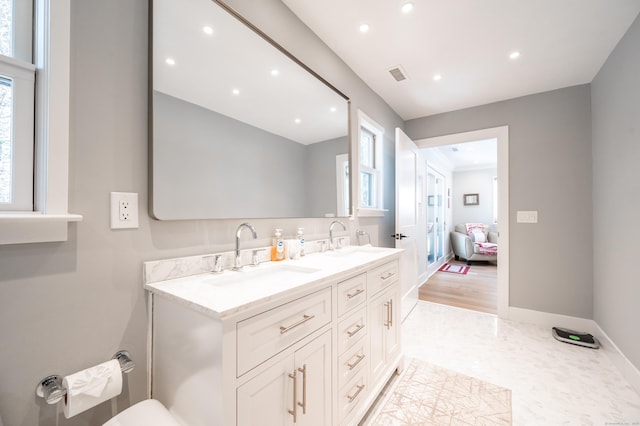 bathroom featuring double vanity, baseboards, visible vents, and a sink