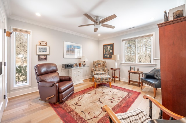 sitting room with ornamental molding, visible vents, baseboards, and wood finished floors