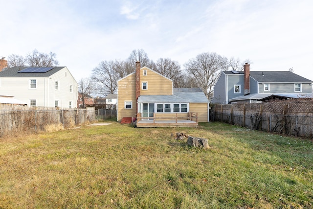 back of house featuring a fenced backyard, a yard, and a wooden deck