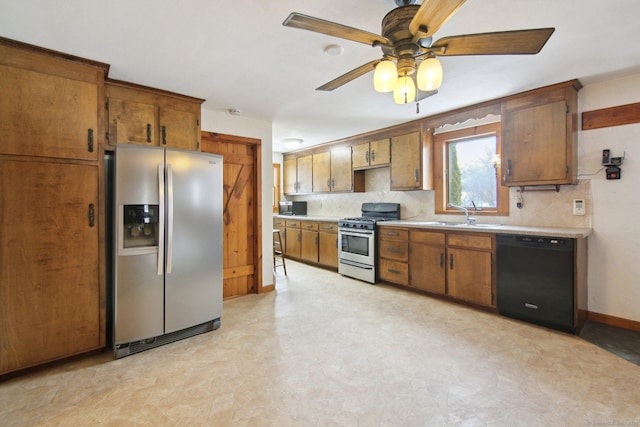 kitchen featuring brown cabinetry, appliances with stainless steel finishes, a sink, light countertops, and backsplash