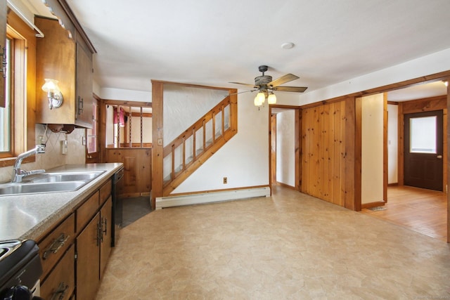 kitchen with range, a baseboard heating unit, a sink, ceiling fan, and plenty of natural light