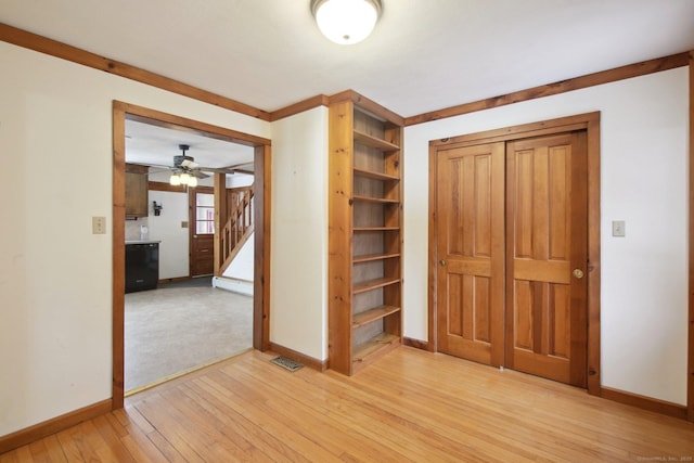 unfurnished bedroom with light wood-type flooring, visible vents, baseboards, and a closet