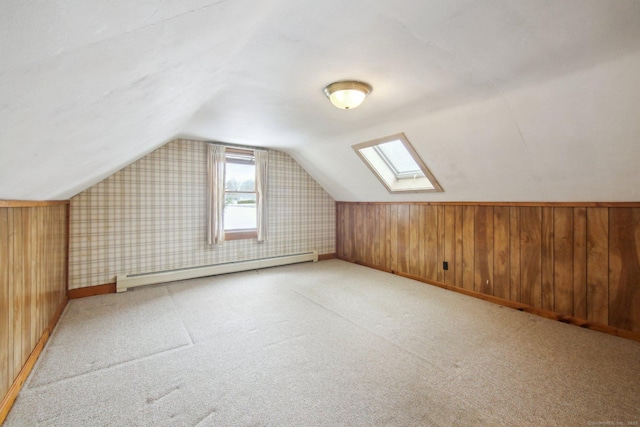 bonus room with a baseboard radiator, wooden walls, light colored carpet, baseboards, and vaulted ceiling