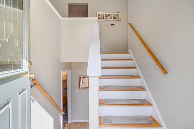 staircase with wood finished floors and baseboards