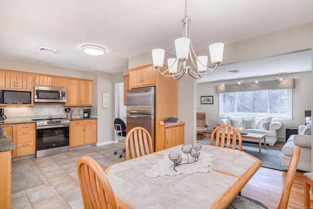 dining room with baseboards, visible vents, and an inviting chandelier