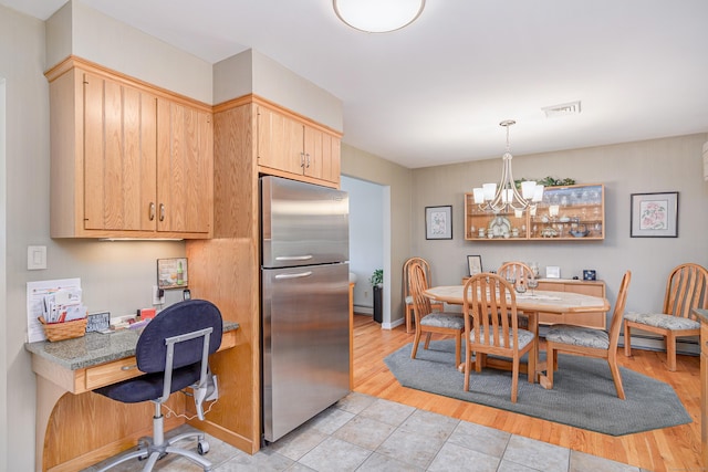 kitchen with visible vents, freestanding refrigerator, an inviting chandelier, light wood-style floors, and pendant lighting