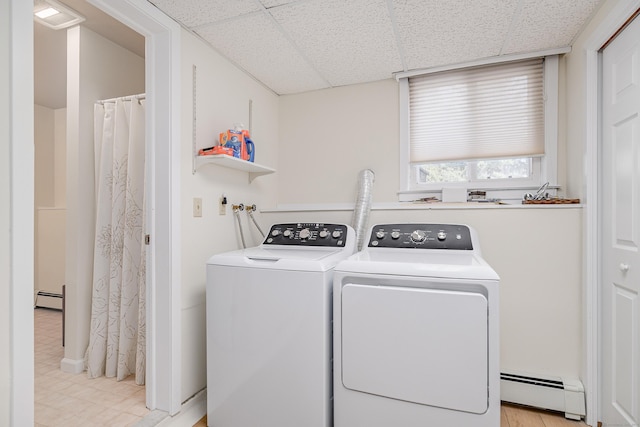 laundry room with laundry area, washing machine and dryer, and a baseboard heating unit