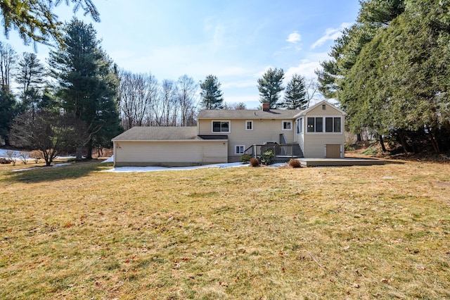 rear view of house featuring a chimney, a yard, and a deck