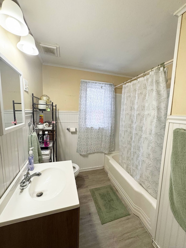 full bathroom featuring vanity, wood finished floors, visible vents, wainscoting, and toilet