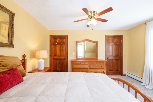 bedroom with carpet floors, baseboard heating, and a ceiling fan