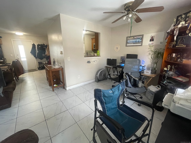 office area featuring marble finish floor, a ceiling fan, and baseboards