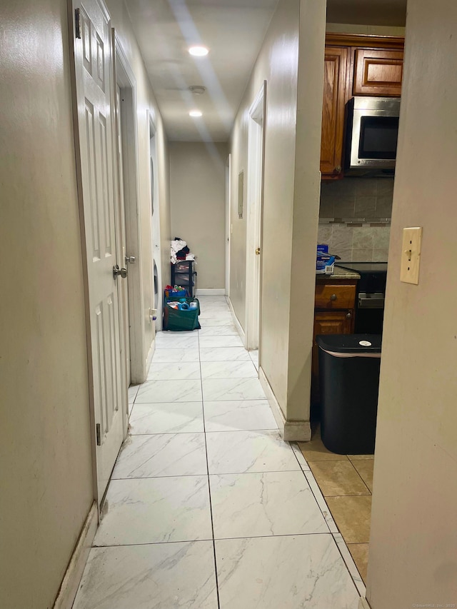 corridor with recessed lighting, marble finish floor, and baseboards