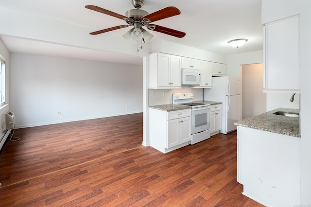 kitchen with white appliances, a sink, light stone counters, and white cabinets