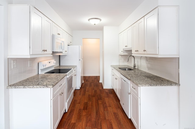 kitchen featuring light stone counters, white appliances, white cabinetry, and a sink