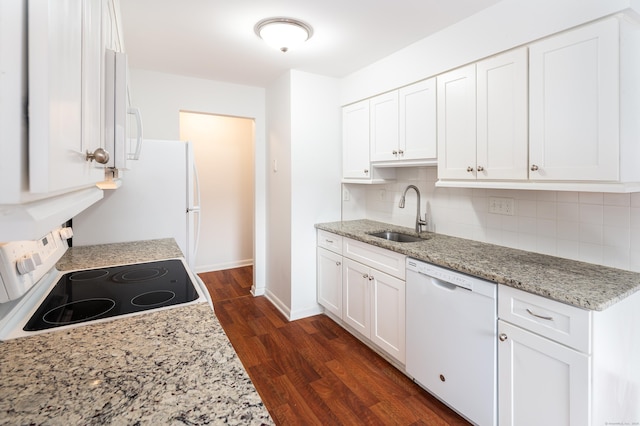 kitchen with light stone counters, decorative backsplash, white cabinetry, a sink, and white appliances