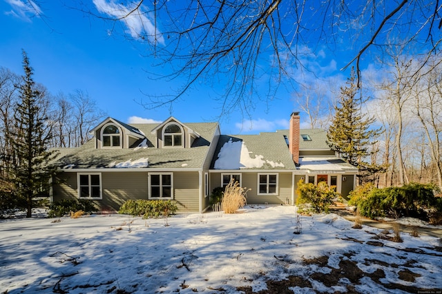 snow covered property featuring a chimney