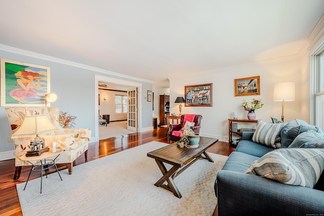 living room featuring ornamental molding, wood finished floors, and baseboards