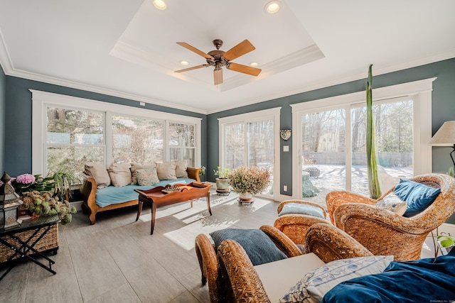 sunroom with ceiling fan and a tray ceiling