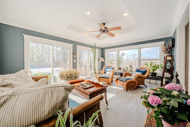 sunroom featuring ceiling fan, a tray ceiling, and a healthy amount of sunlight