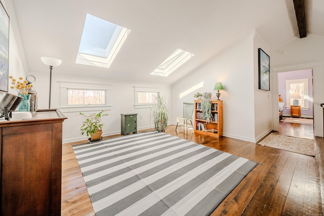 sitting room with lofted ceiling with skylight, hardwood / wood-style flooring, and baseboards