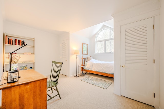 bedroom featuring lofted ceiling, light colored carpet, and baseboards