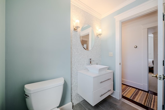 ensuite bathroom with baseboards, toilet, ensuite bath, ornamental molding, and vanity