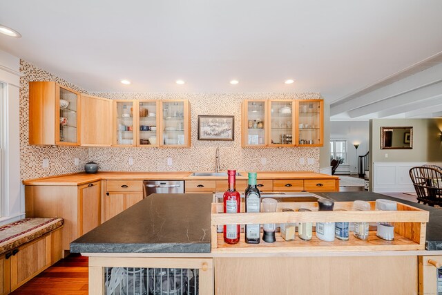 kitchen featuring dark wood-style flooring, tasteful backsplash, glass insert cabinets, a sink, and dishwasher