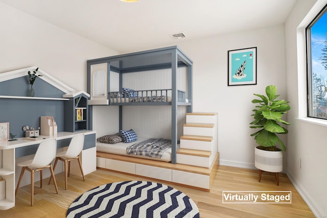 bedroom featuring baseboards, visible vents, and wood finished floors