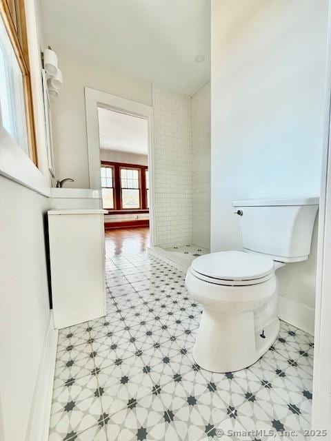 full bath with baseboards, a shower stall, toilet, and tile patterned floors