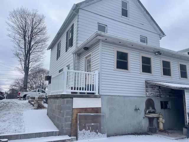 snow covered house featuring a garage