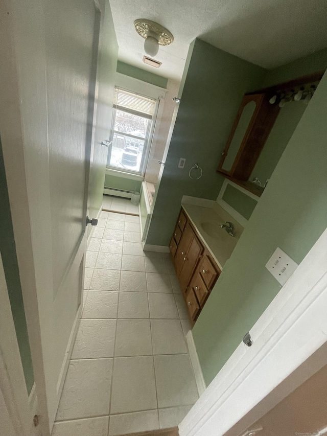 bathroom featuring a baseboard heating unit, vanity, visible vents, and tile patterned floors