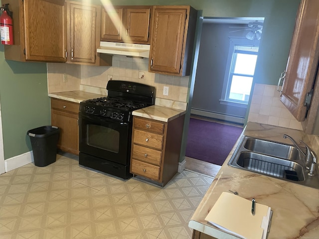 kitchen featuring under cabinet range hood, black range with gas stovetop, and light countertops