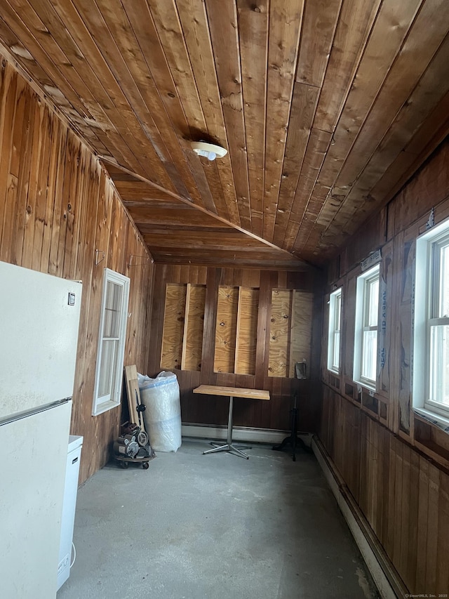 miscellaneous room with lofted ceiling, a baseboard heating unit, wood ceiling, wooden walls, and concrete flooring