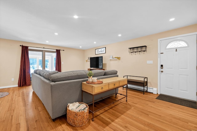 living area featuring light wood finished floors, baseboards, baseboard heating, and recessed lighting