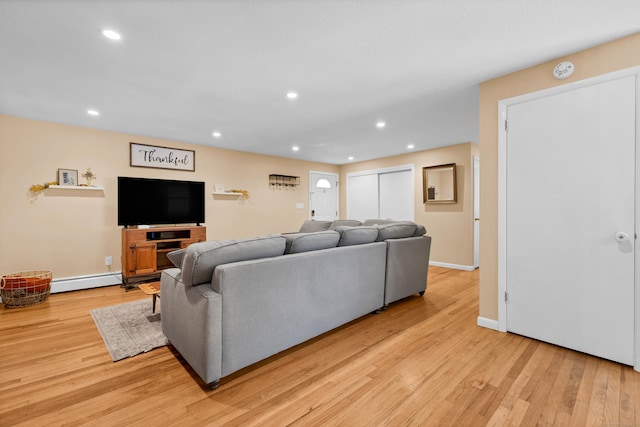 living area with light wood finished floors, a baseboard radiator, and recessed lighting