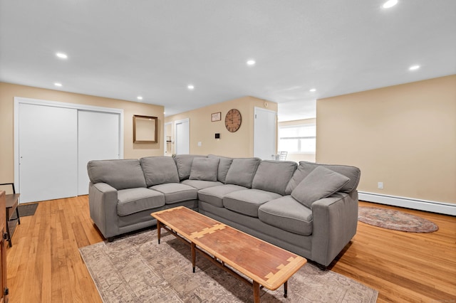 living area with recessed lighting, light wood-style flooring, and a baseboard radiator